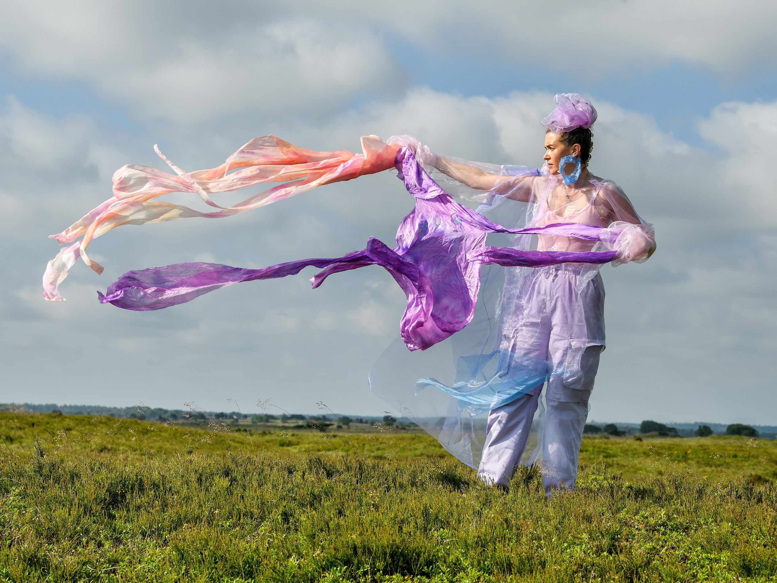 Kunstværket Walking Landscapes af Sonja Strange, der forestiller kvinde på græsmark med flyvende tørklæder.